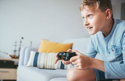 Person playing video game on a couch in a bright living room