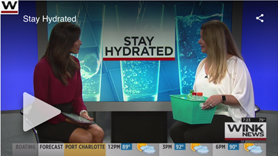 Two women in a TV studio discuss “Stay Hydrated” on a news segment.