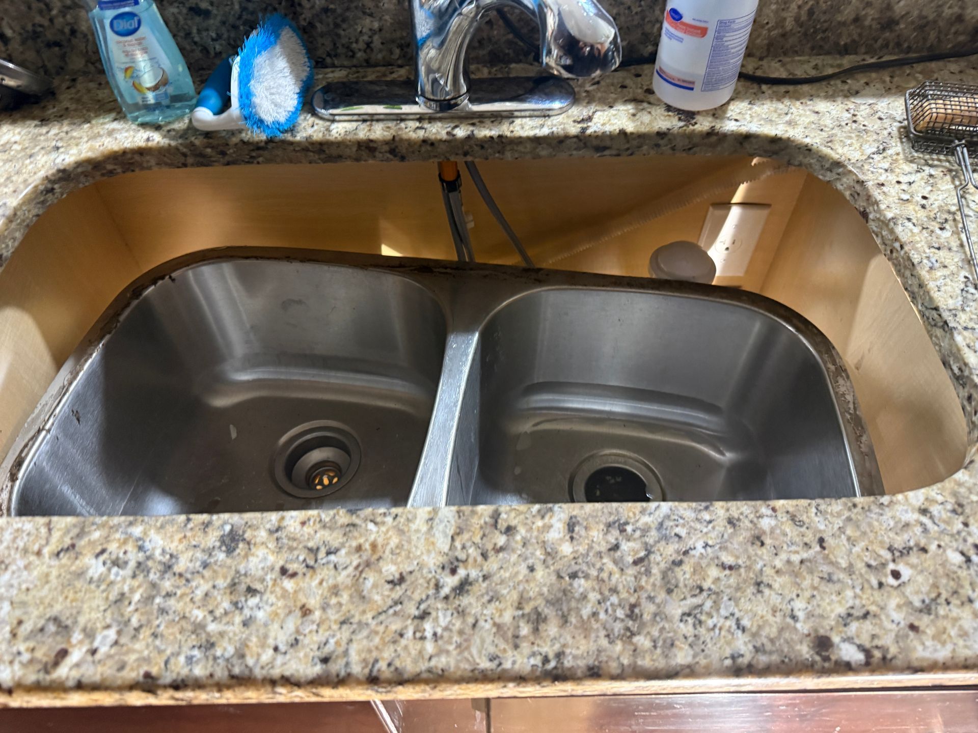 Stainless steel double sink set into a granite countertop.