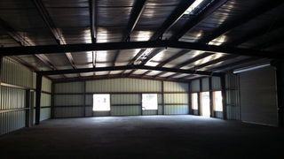 Empty metal warehouse interior with high ceiling and large open floor space