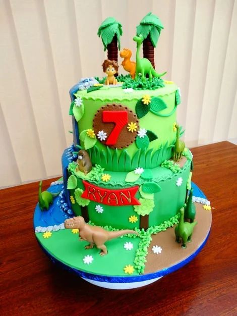 Two-tier green birthday cake with a red “7,” palm trees, and jungle animal decorations