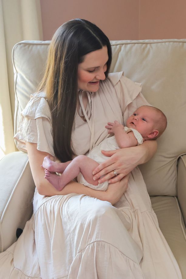 A woman is sitting in a chair holding a baby.