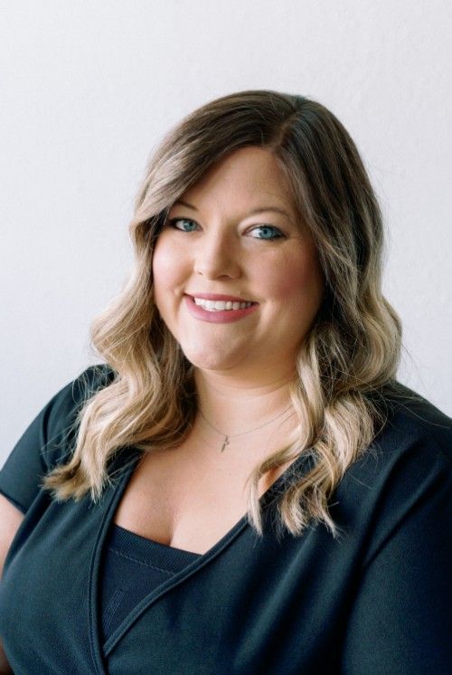 A woman in a black shirt is smiling for the camera.