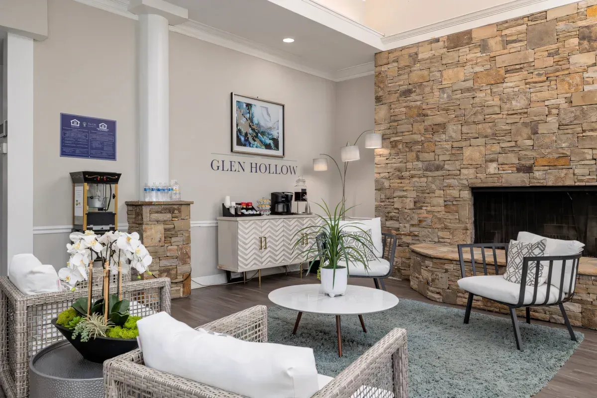 Modern waiting room with stone fireplace, white chairs, and round coffee table