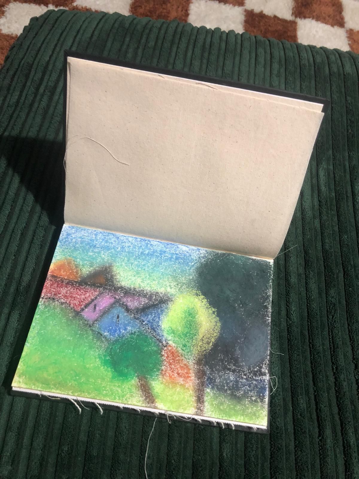 Open cardboard box with a colorful abstract drawing on the inside bottom panel