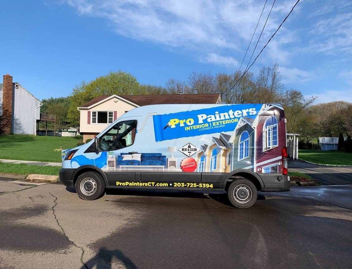 Blue Pro Painters van parked on a residential street in front of houses on a sunny day