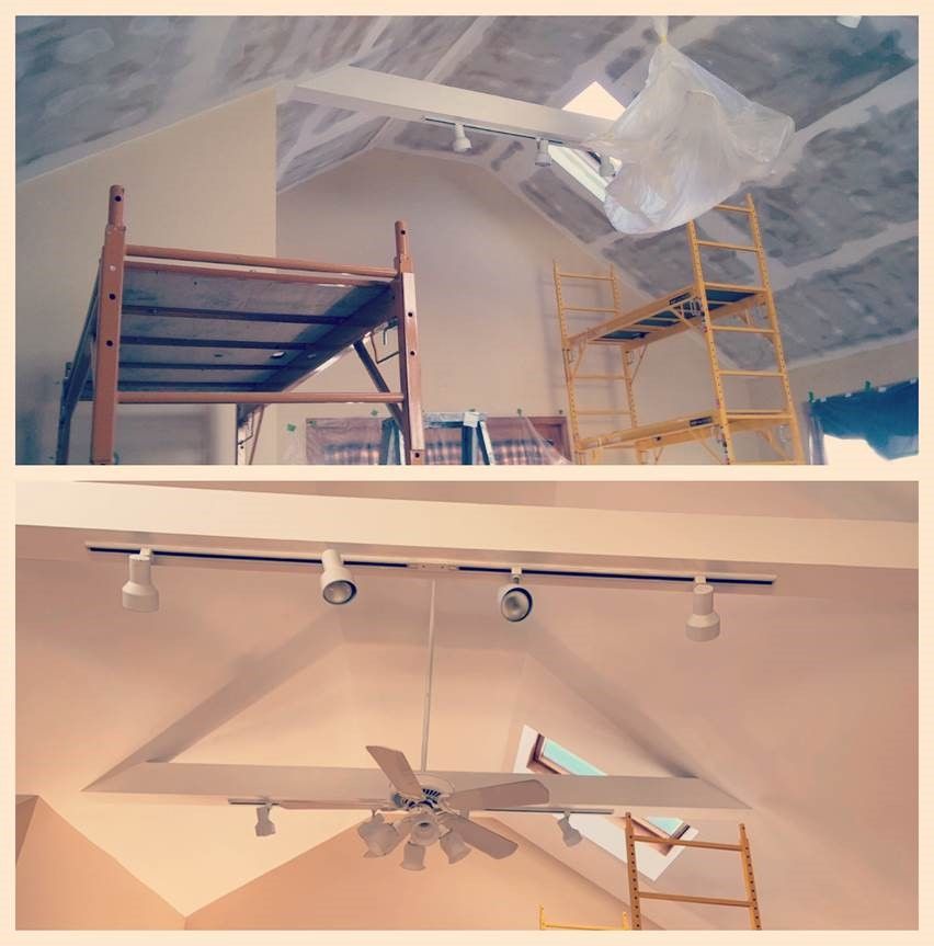 Ceiling painting in progress with scaffolding, covered furniture, and track lights/fan installed
