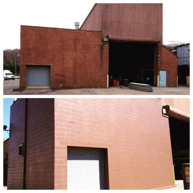 Reddish-brown industrial building with a loading bay and roll-up garage door.