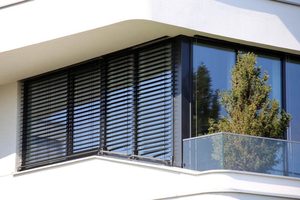A white building with large windows and black blinds — Phoenix Blinds In Nowra, NSW