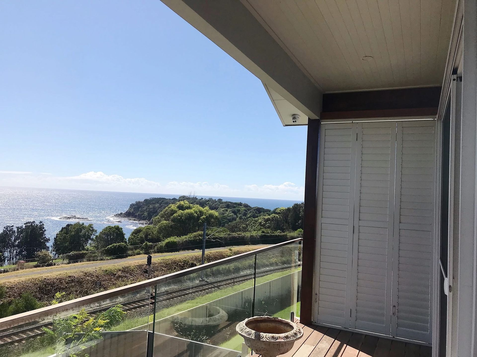 There is a balcony with a view of the ocean. — Phoenix Blinds In Albion Park Rail, NSW