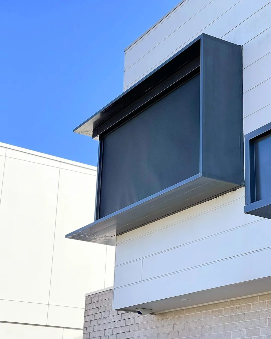 A white building with large windows and black blinds — Phoenix Blinds In Nowra, NSW