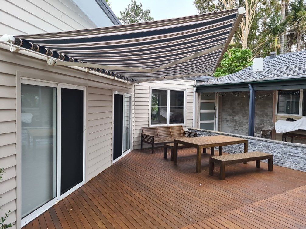 A Deck with A Table and Benches Under an Awning — Phoenix Blinds In Albion Park Rail, NSW