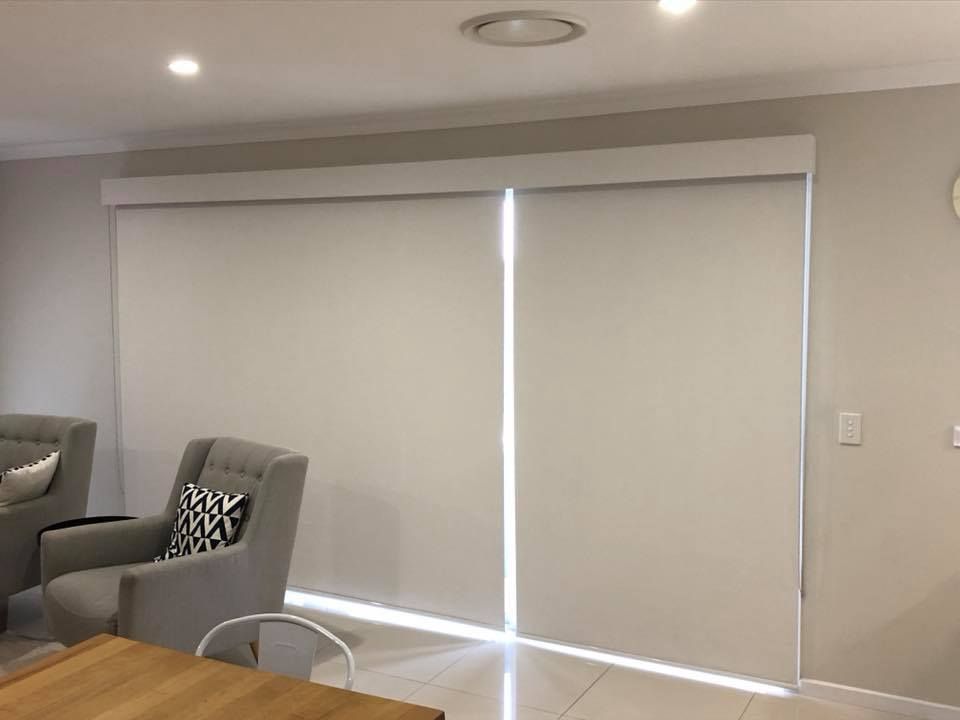 A Living Room with A Couch, Chair, Table and Blinds on The Windows — Phoenix Blinds In Albion Park Rail, NSW