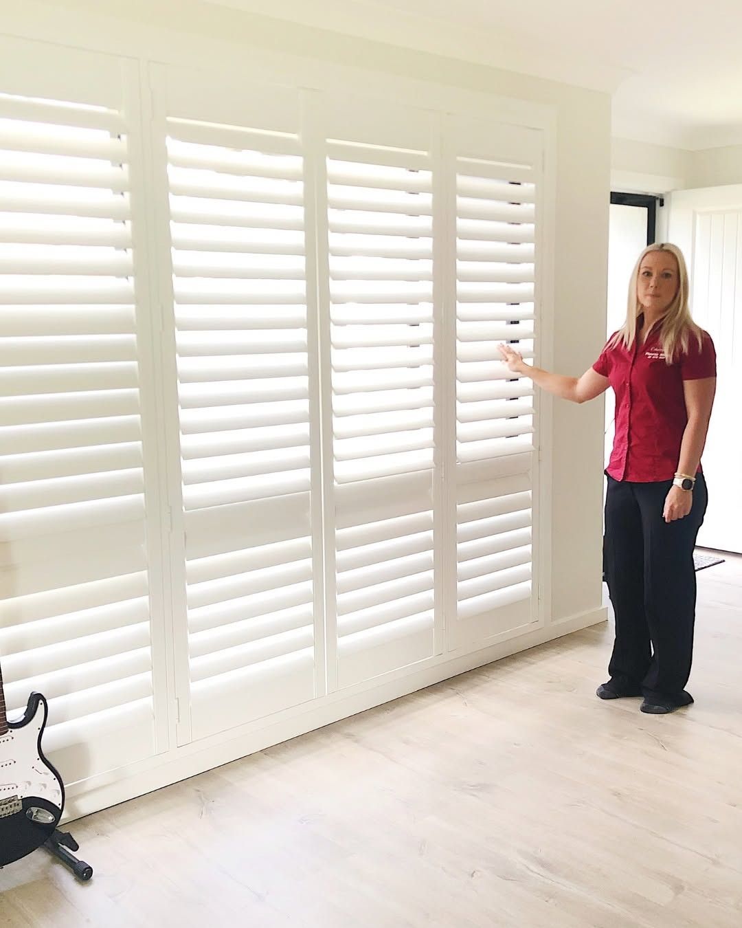 Woman Beside White Plantation Shutters in Wollongong