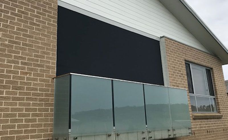 A Brick Building with A Balcony on The Side of It — Phoenix Blinds In Albion Park Rail, NSW
