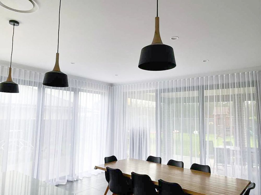A white building with large windows and black blinds — Phoenix Blinds In Nowra, NSW
