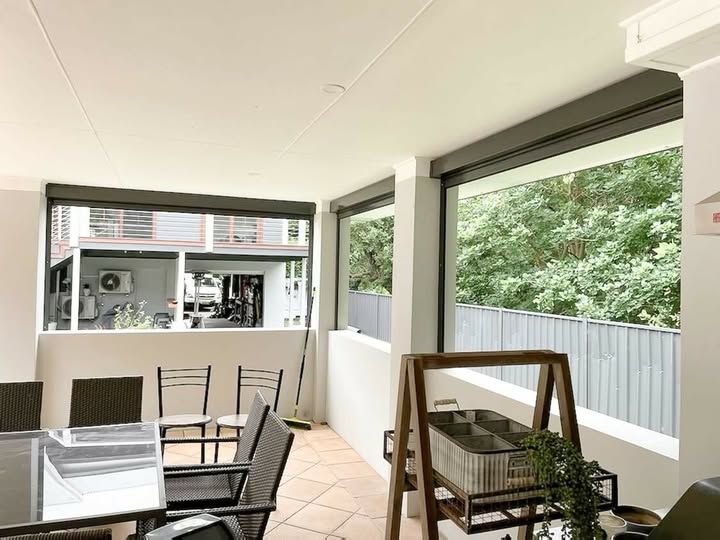 A Living Room with A Table and Chairs and A Large Window — Phoenix Blinds In Shellharbour, NSW