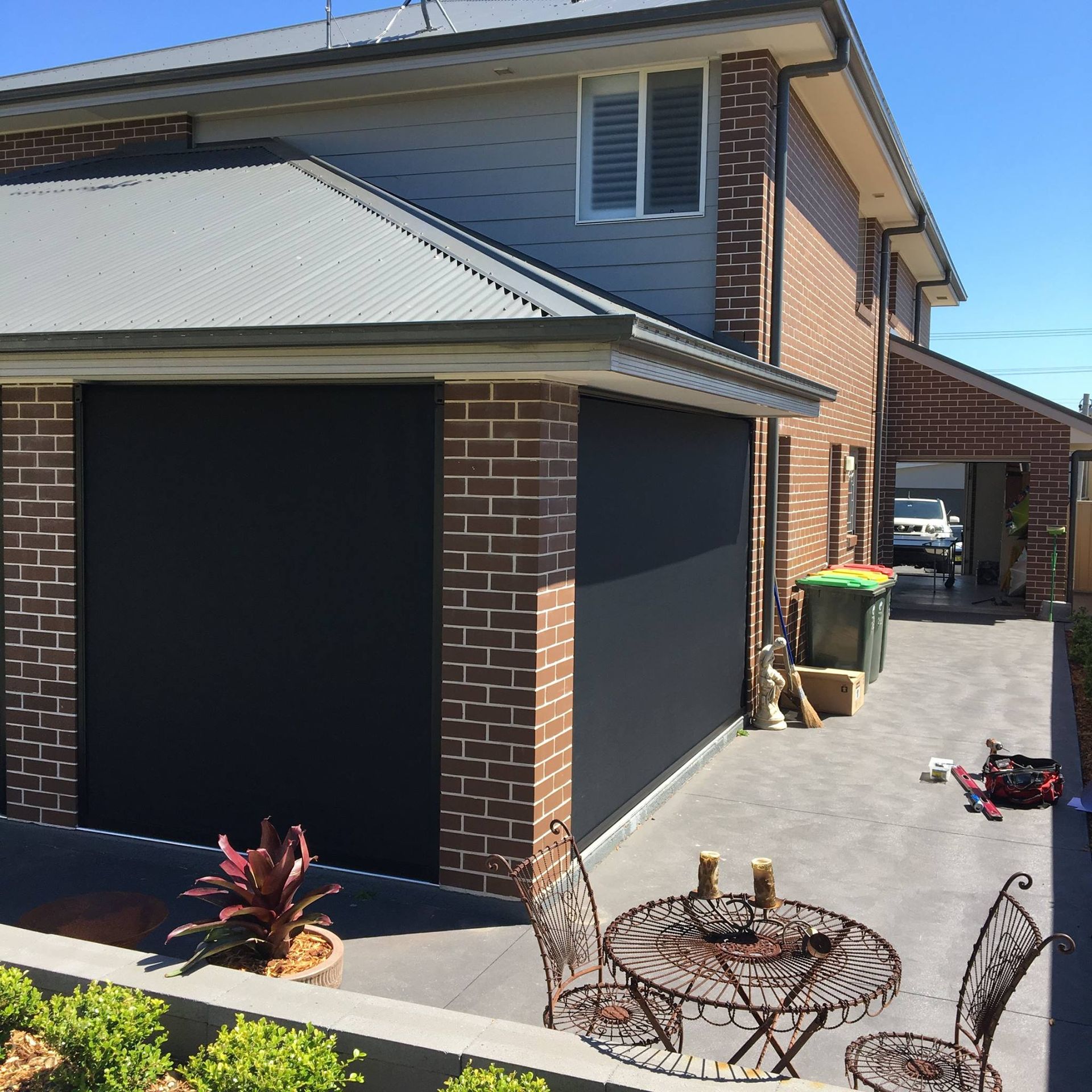 Two Windows on A Brick Building with Black Roller Shutters — Phoenix Blinds In Albion Park, NSW