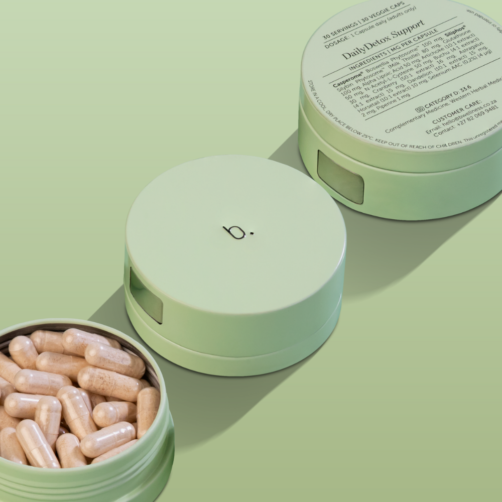 Sage green pill container with capsules, one open, one closed, and one lid upside down with supplement facts on a green base.