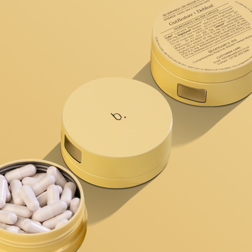 Three light yellow circular pill containers, one open displaying white capsules, on a matching yellow background.