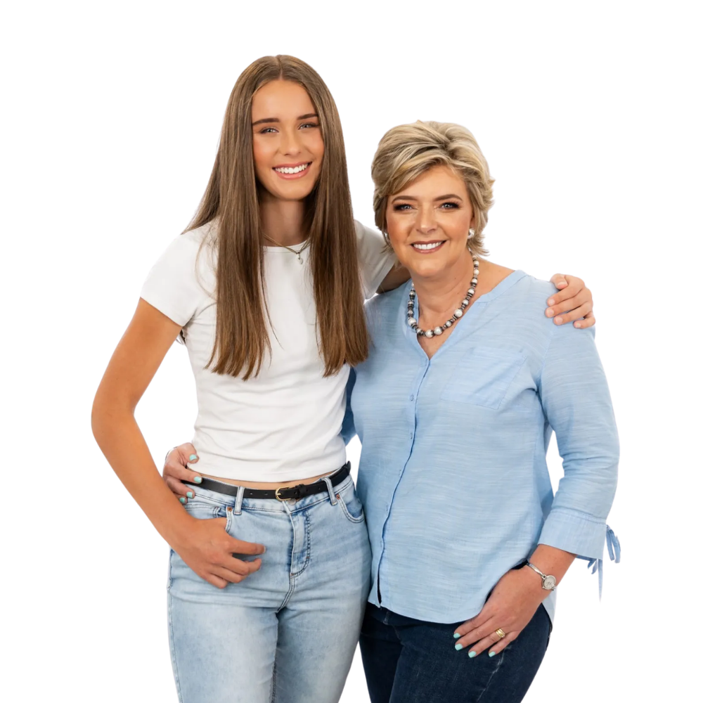 Two people standing together, smiling and embracing, against a plain white background.
