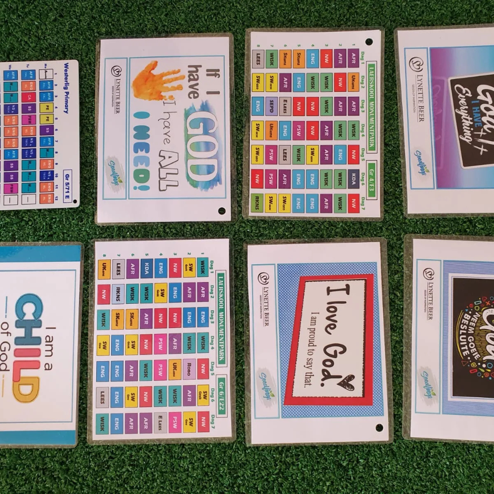 A grid of eight religious-themed flashcards featuring inspirational quotes and colored schedules laid on green turf.