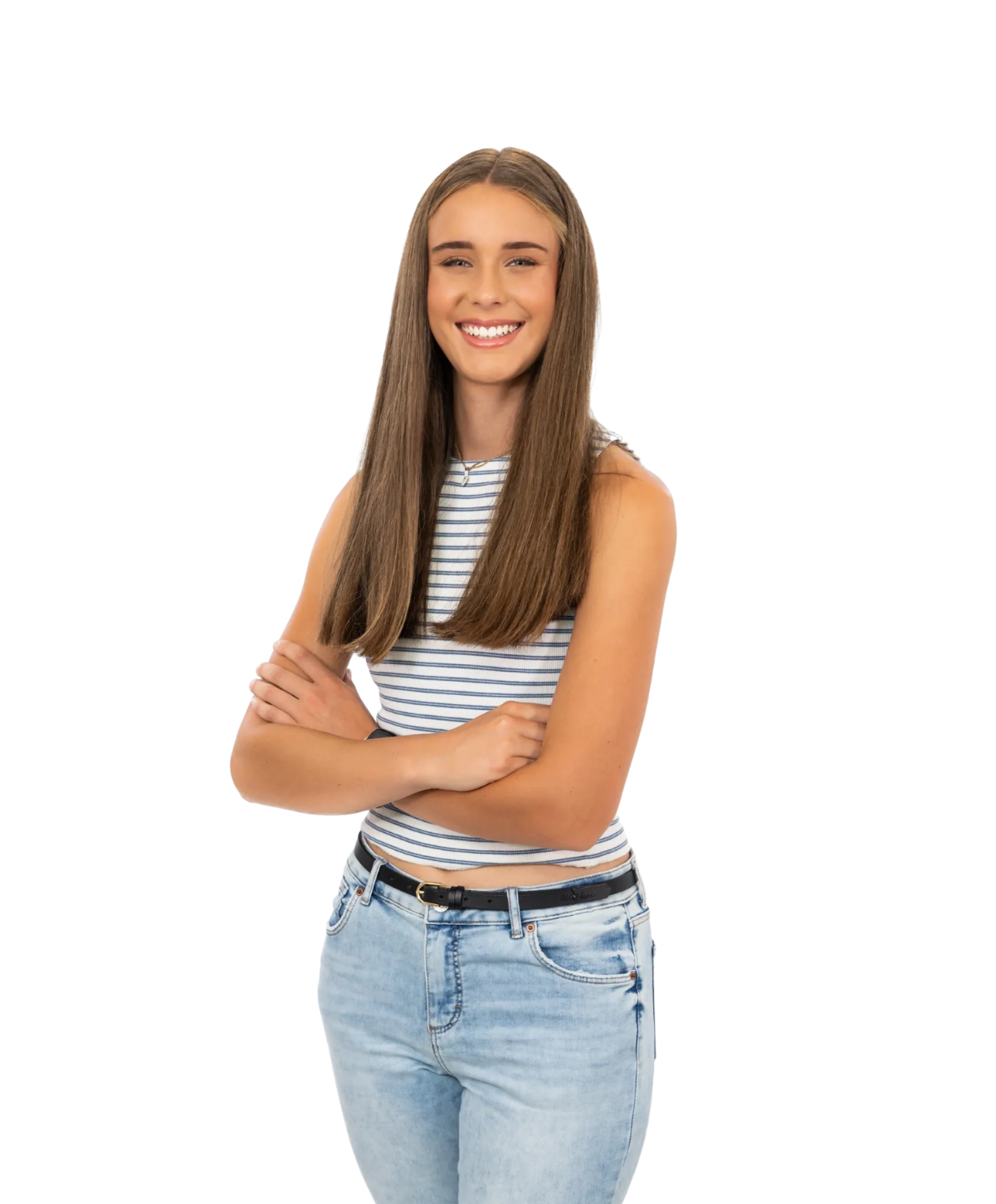 A person with long brown hair, wearing a striped sleeveless top and light-wash jeans, smiling with arms crossed.