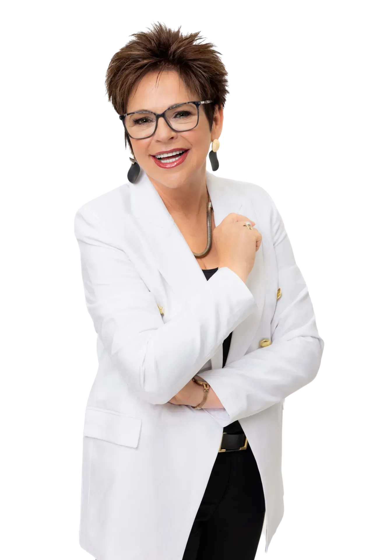 A person with short hair and glasses, wearing a white blazer and black top, smiling with arms crossed against white.