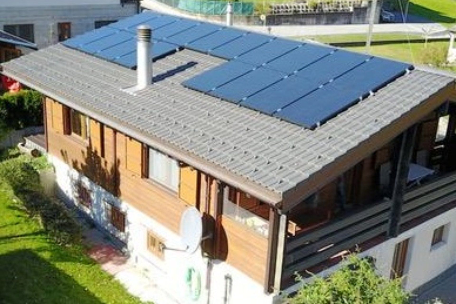 Casa con pannelli solari sul tetto e parabola satellitare in una giornata di sole