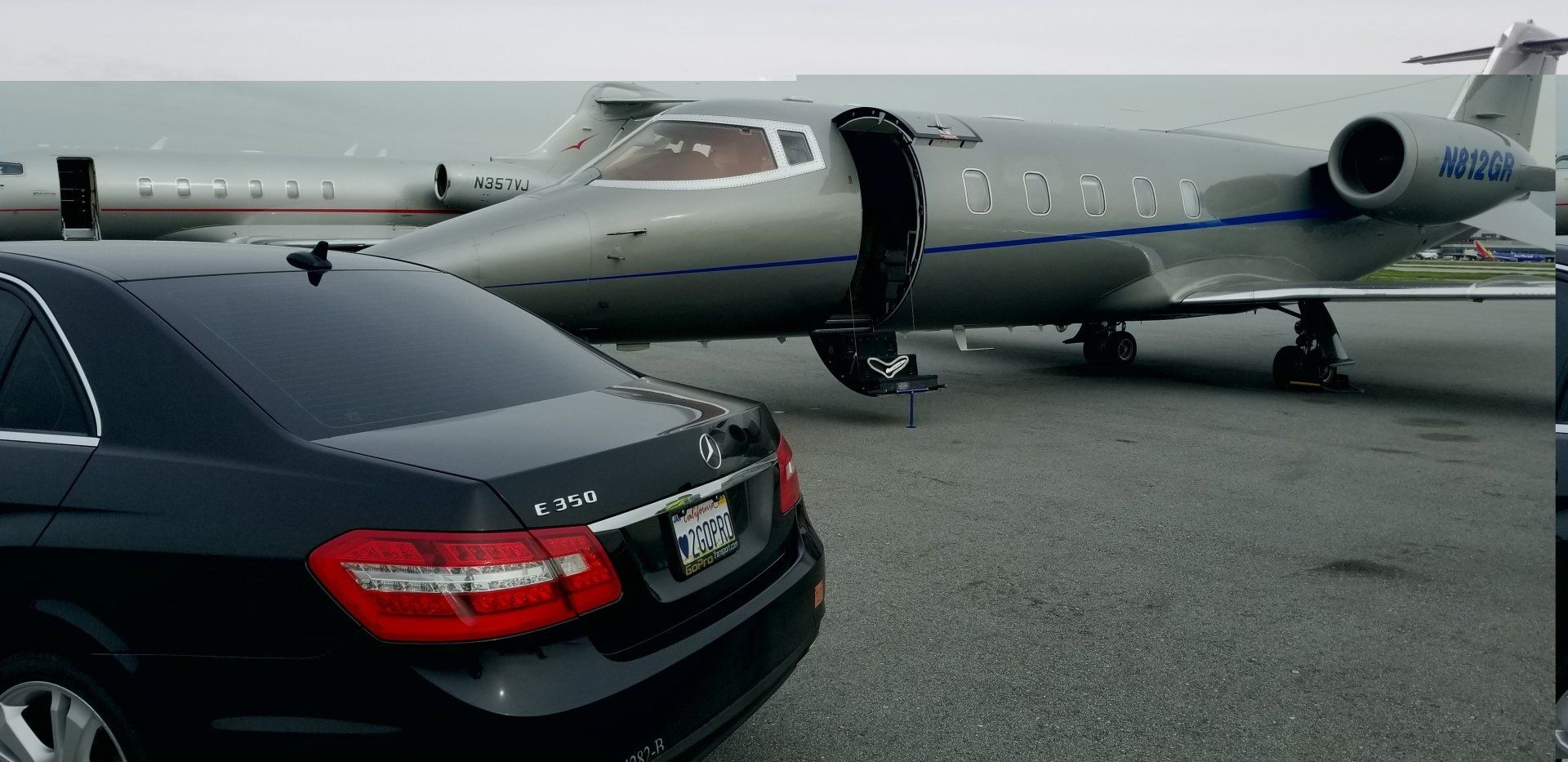 A car is parked in front of a private jet.