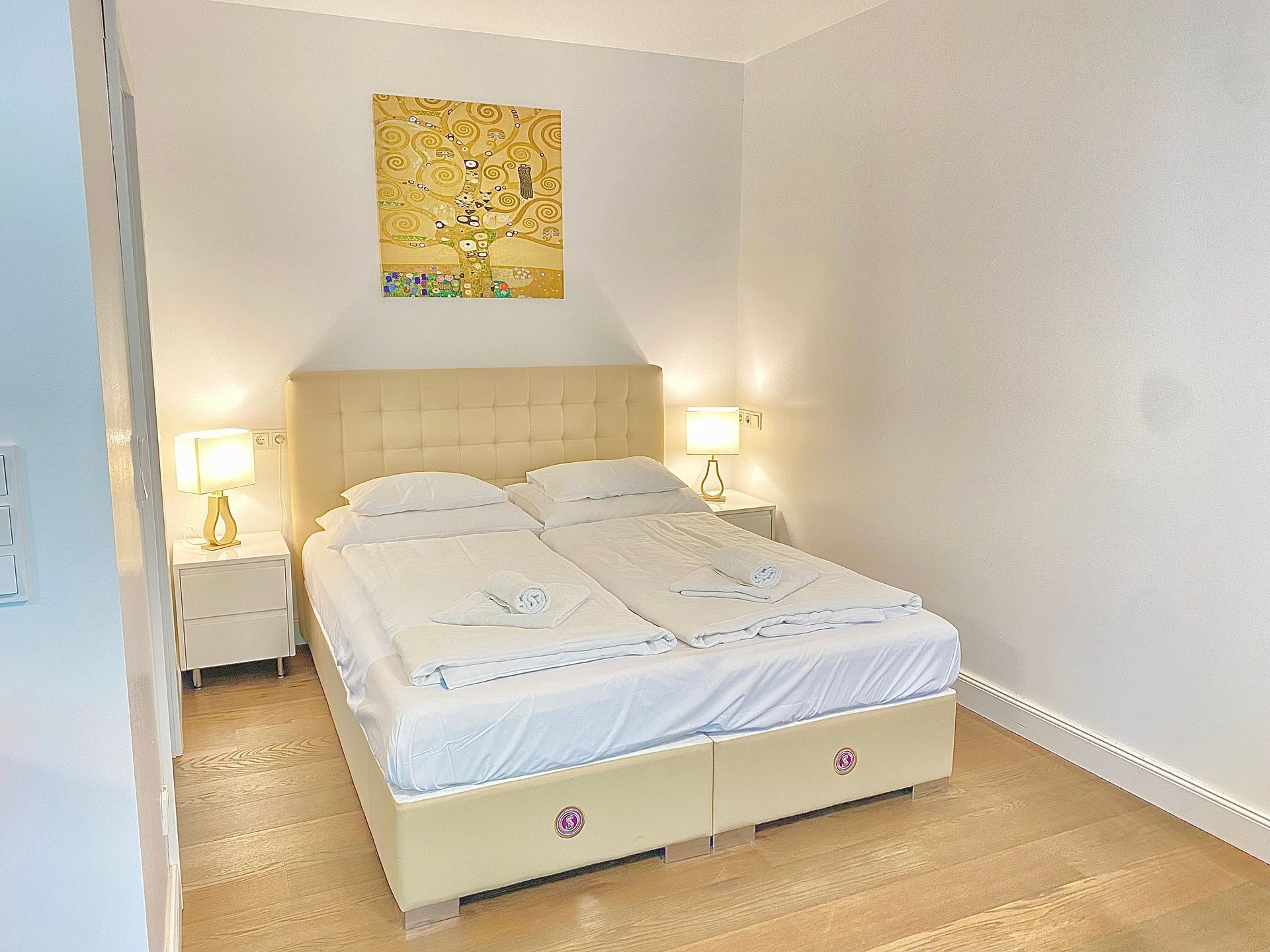 There is a painting on the wall above the bed in the bedroom.