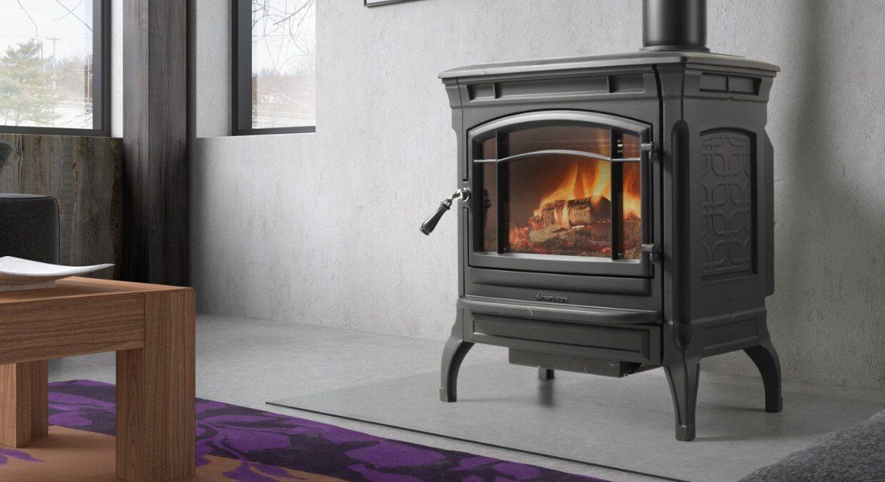 Una stufa in ghisa con il fuoco acceso all'interno, in una stanza accogliente.