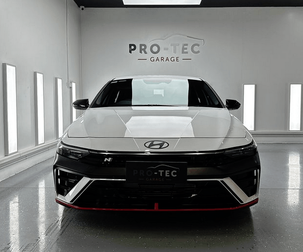 A close up of a white car hood with black vents also got an application of Ceramic Coating.