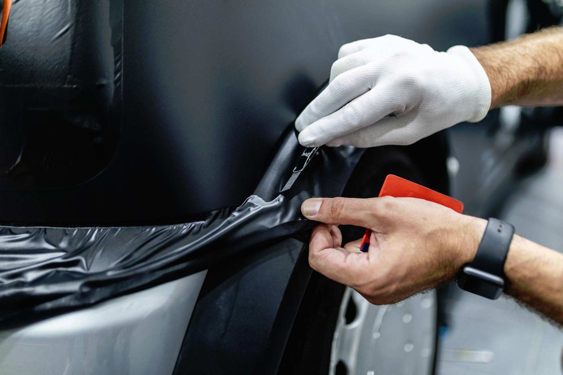 a person is wrapping a car in black plastic
