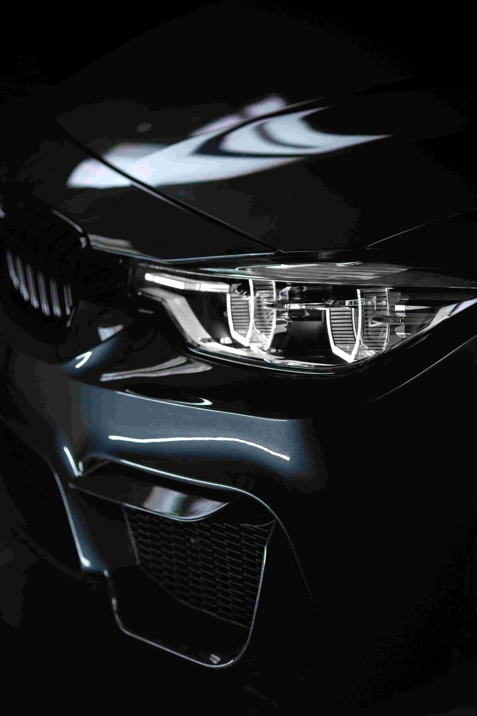 a close up of the headlights of a black car- detailed