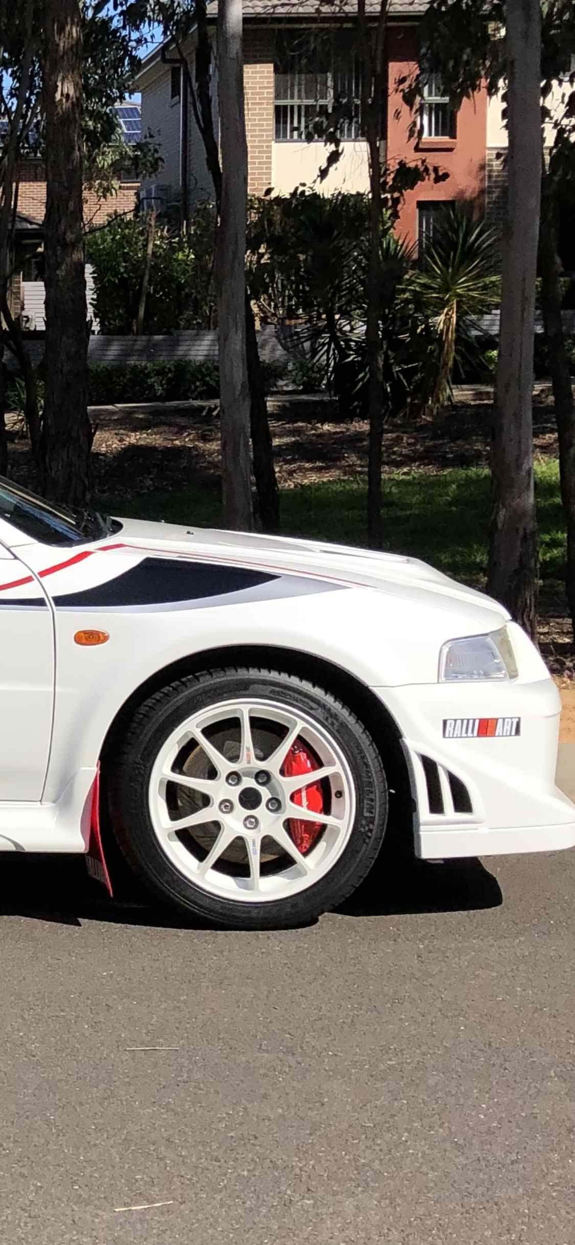 a white car is parked on the side of the road - just applied ceramic coating
