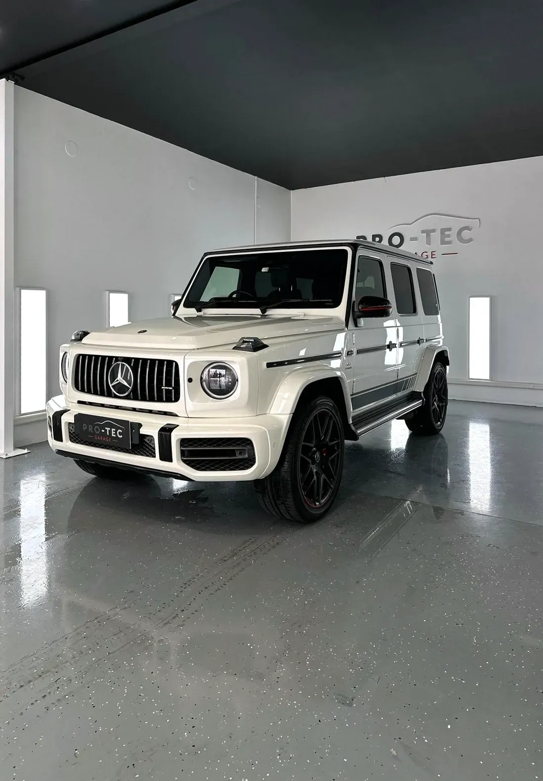 A Mercedes Benz G63 AMG in white color is parked in a garage after having Ceramic coating applied.