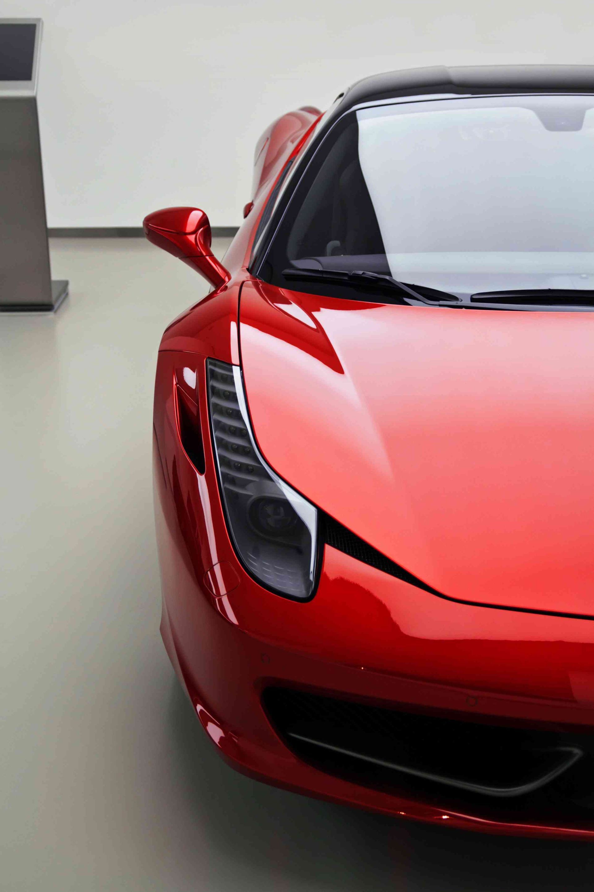 a red sports car is parked in a showroom - with a ceramic coating applied