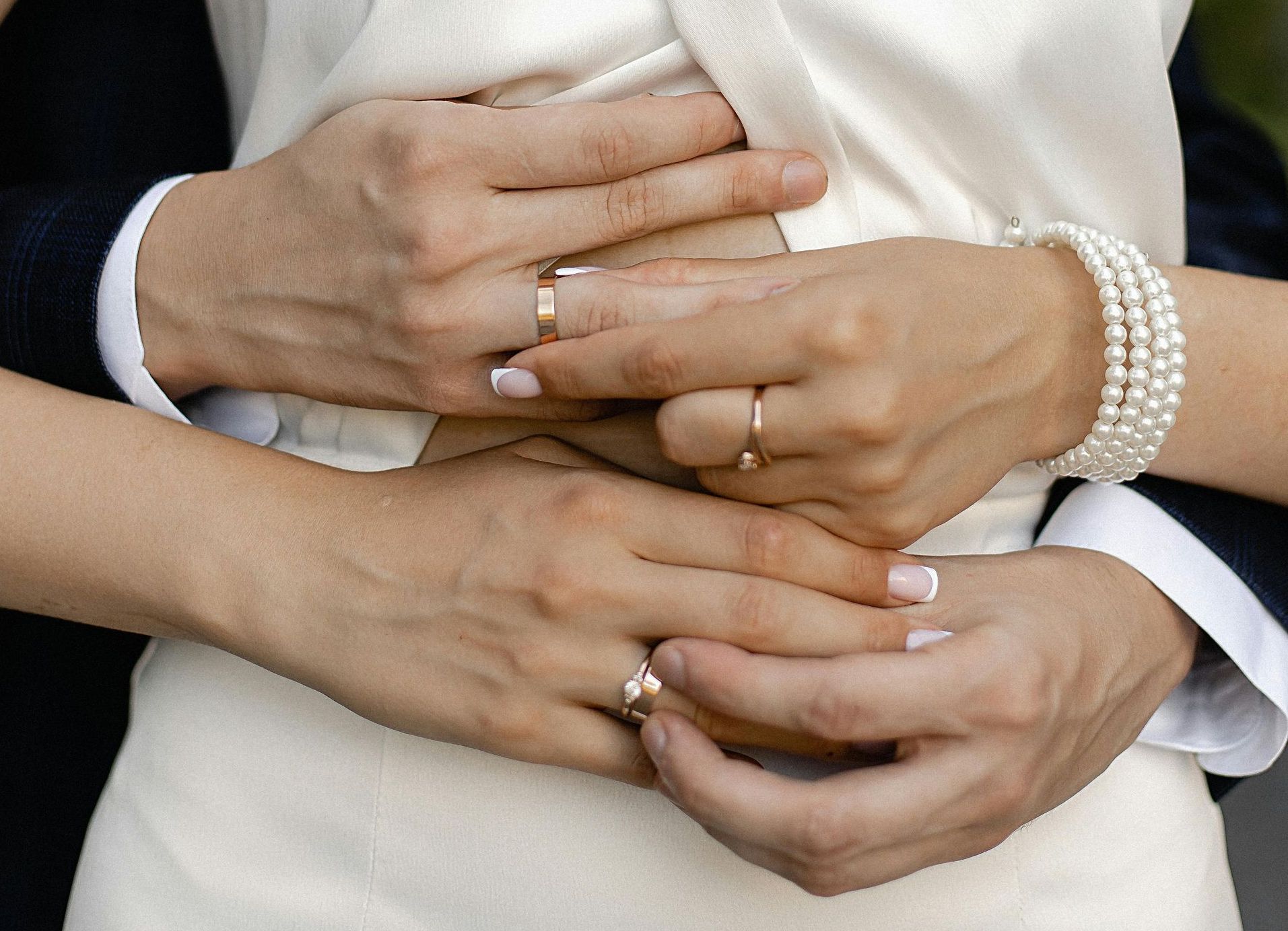 married couple husbands-grooms arms wrapped around wifes-brides waist showing rings
