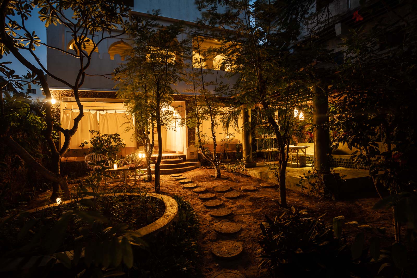 Sweet Banana House garden at night with soft lighting and stone pathway