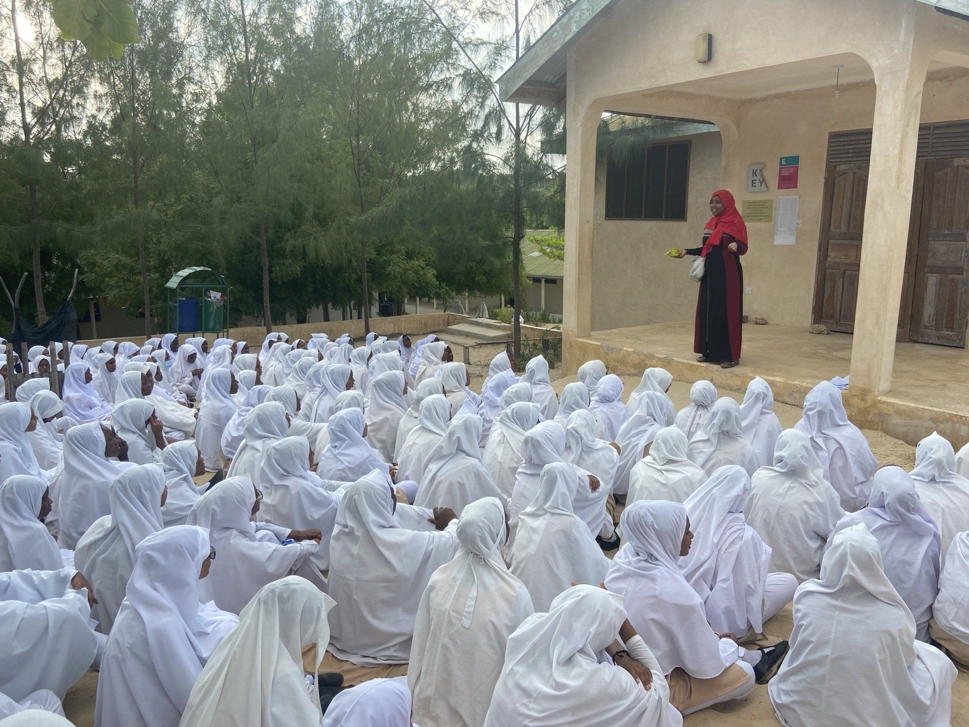 Large group of girls gathered outside for education session