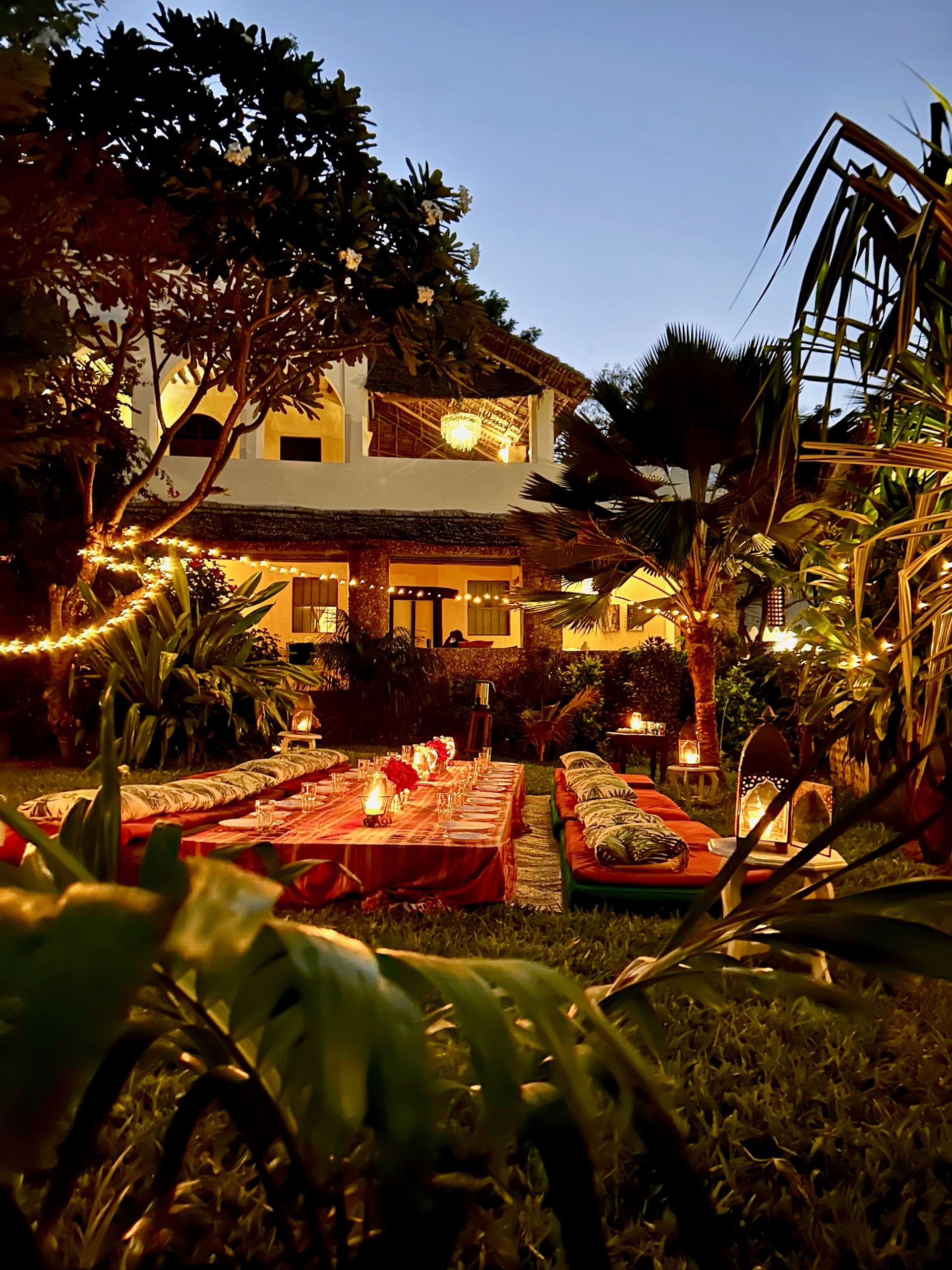 Traditional Swahili-style architecture of Banana House with balconies and lush tropical plants during night view