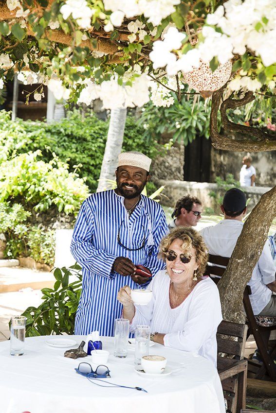 Bougainvillea flowers in the garden at Banana House Lamu. owners enjoying coffee