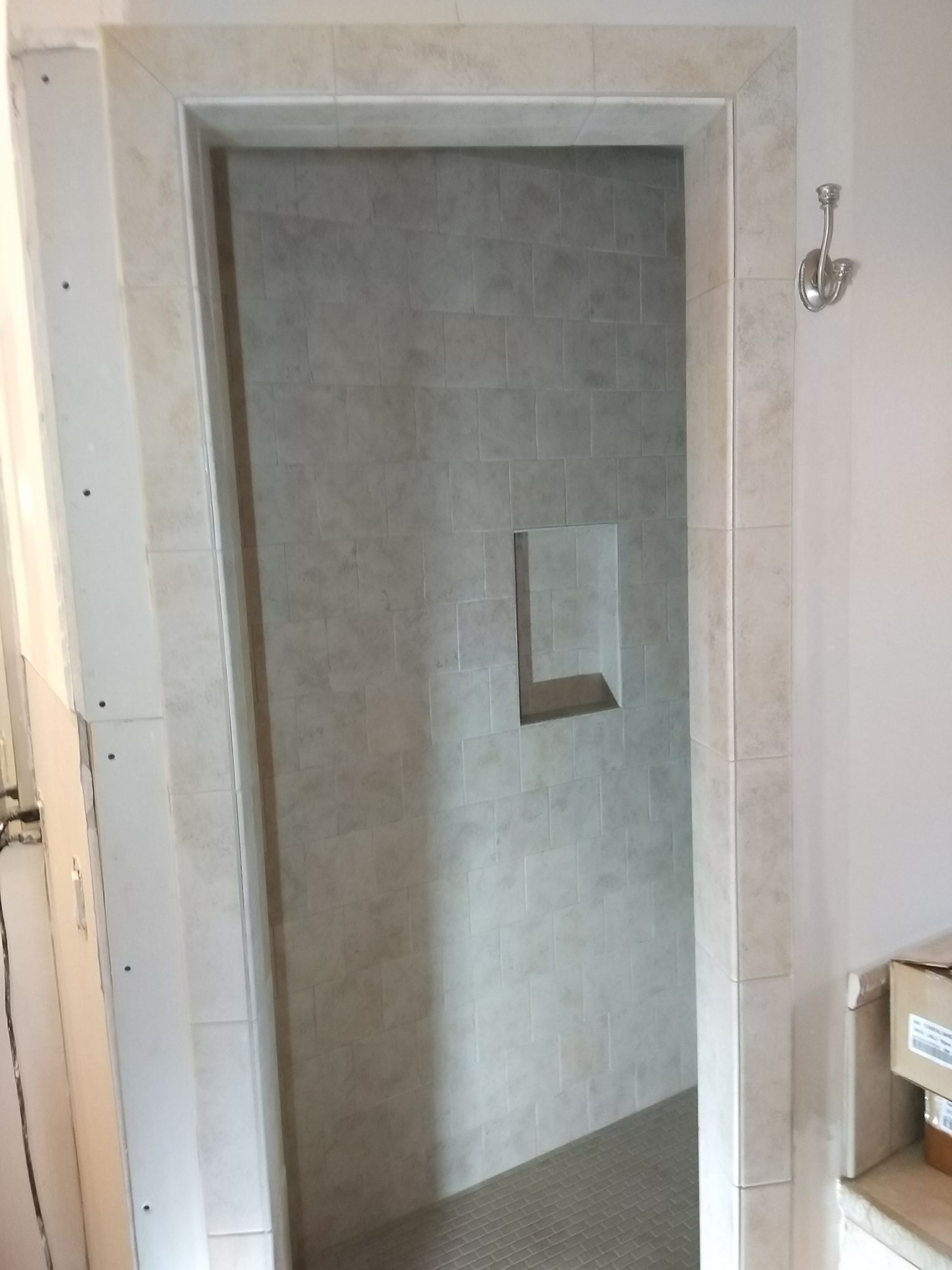 Gray doorway in an unfinished room, with a small wall opening and white walls around it.