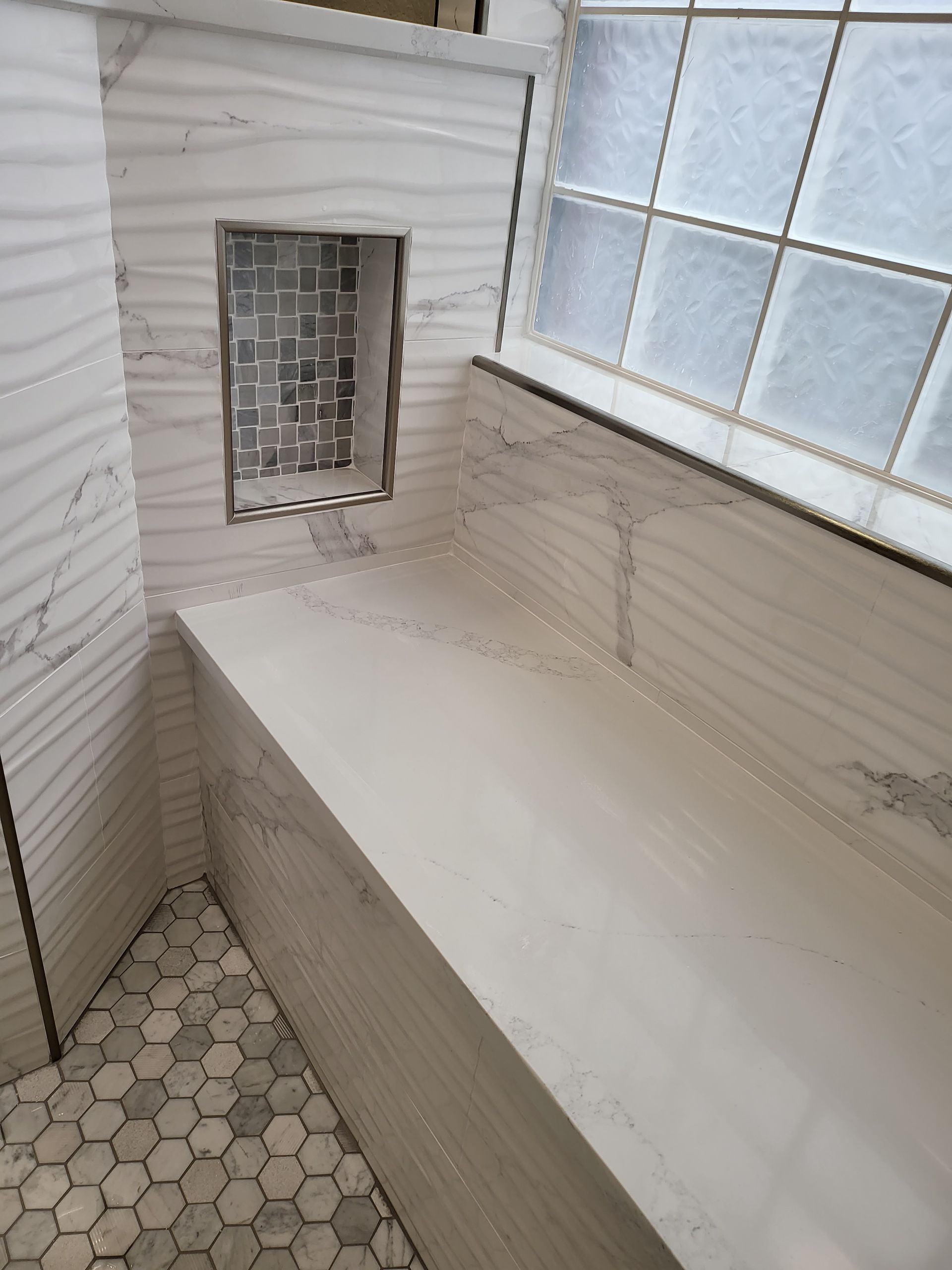 Small tiled bathroom with a built-in tub, barred window, and white horizontal wall paneling.