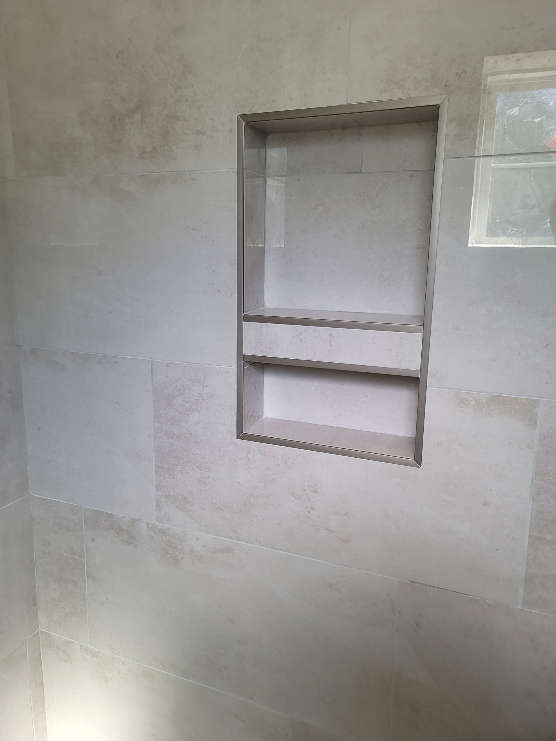 Unfinished interior wall with a rectangular recessed opening and exposed framing.