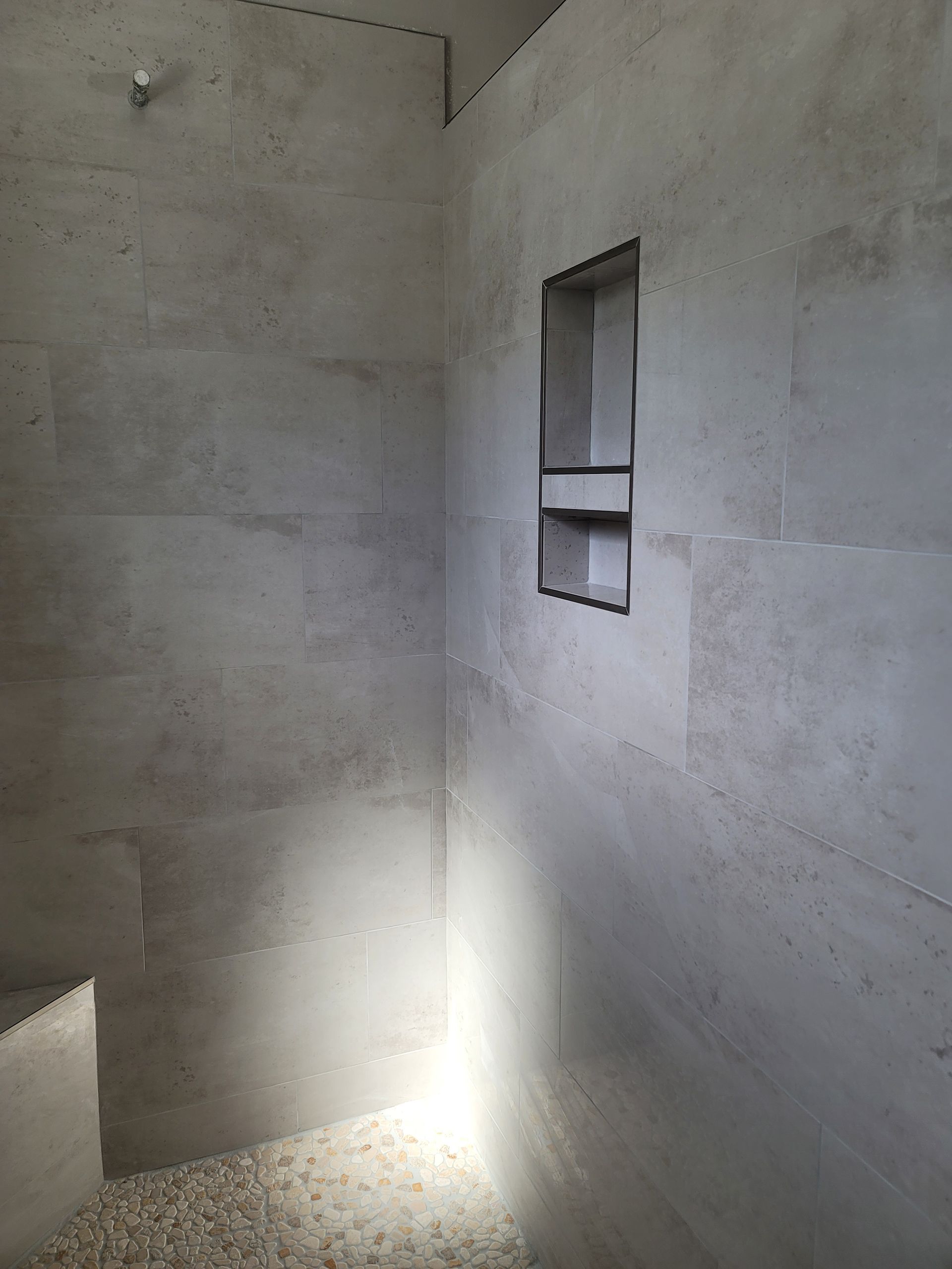 Empty gray concrete room with a small window and bright sunlight on the floor.