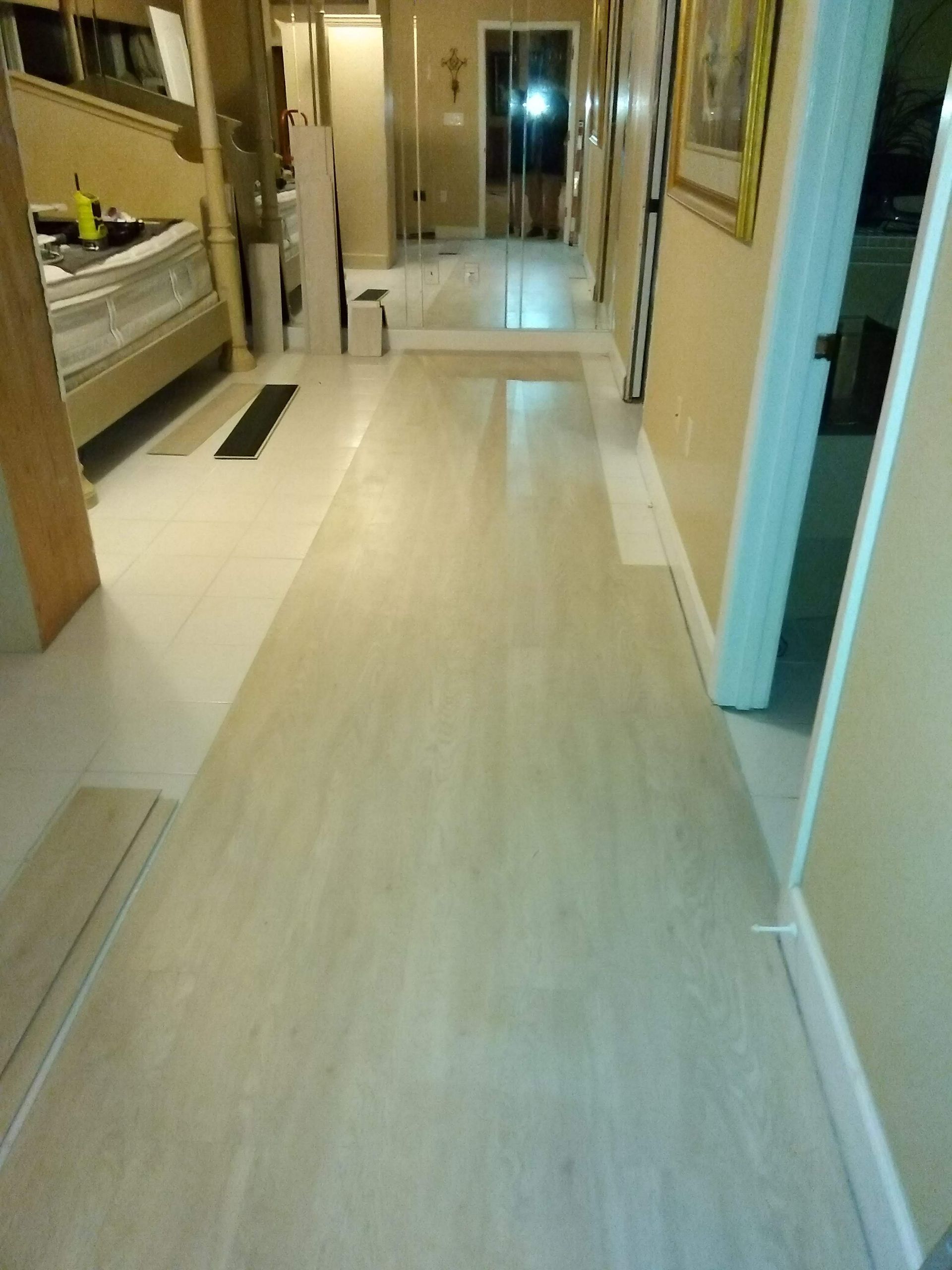 Long hallway with pale wood flooring, bunk beds on the left, and doors along the right wall