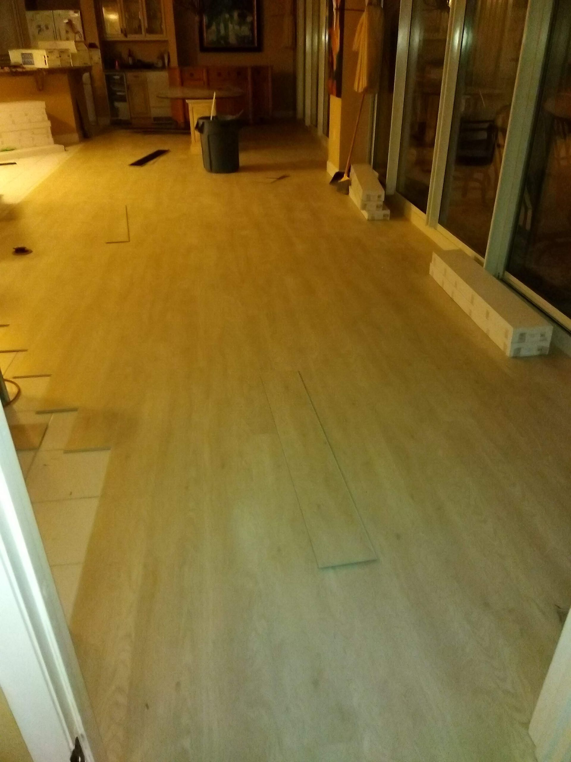 Empty room with a light wood floor and unfinished walls under warm indoor lighting