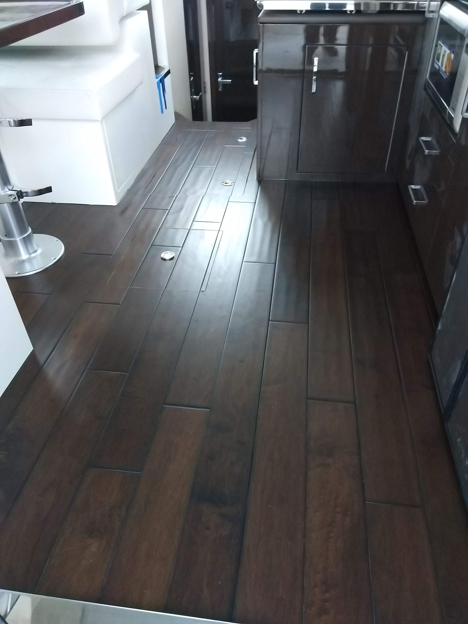 Modern kitchen with dark wood floors, white cabinets, and stainless steel appliances